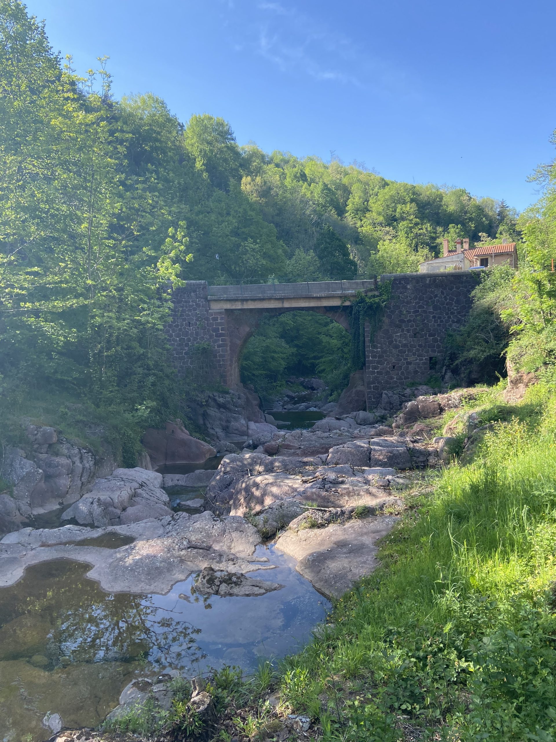 Pont de Can de Baruti au-dessus de la rivière, entouré de végétation.